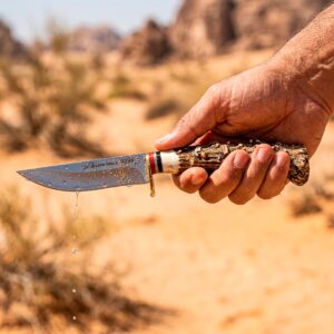 Cuchillo Imitación Cuerno Venado Acero Lion Tools modelo 9396 con hoja de acero inoxidable, mango de plástico imitación cuerno de venado y funda de cuero sintético.